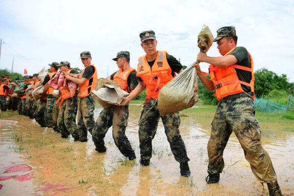 中国、江西省でハ陽湖の堤防を補強するために土嚢運ぶ武装警察部隊（2020年7月13日） - Sputnik 日本