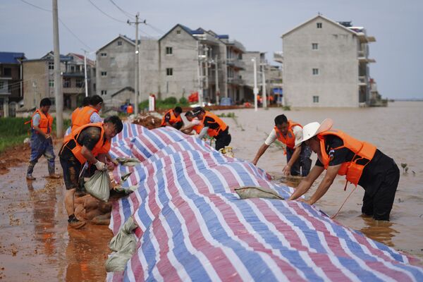 中国江西省ハ陽県で、決壊を防ぐため堤防を建設する作業員（2020年7月11日） - Sputnik 日本