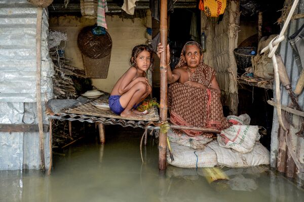 7月16日、バングラデシュのスナムガンジで浸水した家に座る少女と女性 - Sputnik 日本