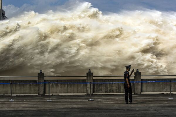 7月19日、中国、湖北省宜昌市の三峡ダムで実施された放流を眺める警備員 - Sputnik 日本