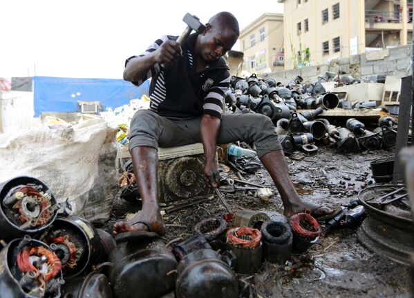 7月18日、ナイジェリア首都アブジャのリサイクルセンターで、廃棄されたコンプレッサーを解体する男性 - Sputnik 日本