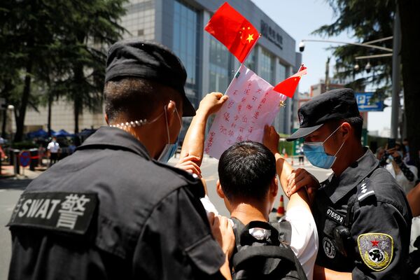 7月27日、中国成都市の米国総領事館前で、中国国旗とプラカードを掲げる男性 - Sputnik 日本