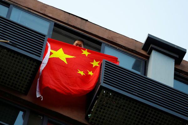 7月26日、中国成都市の米国総領事館の向かいの家から中国国旗を垂らす男性 - Sputnik 日本