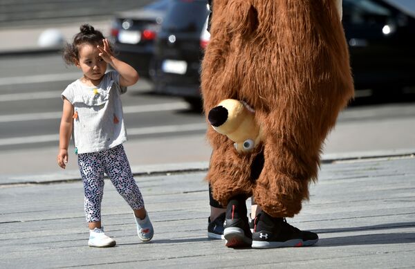 7月24日、ウクライナの首都キエフで、ロシアのアニメ「マーシャと熊」のキャラクター、熊（ミーシャ）の着ぐるみを見つめる少女 - Sputnik 日本