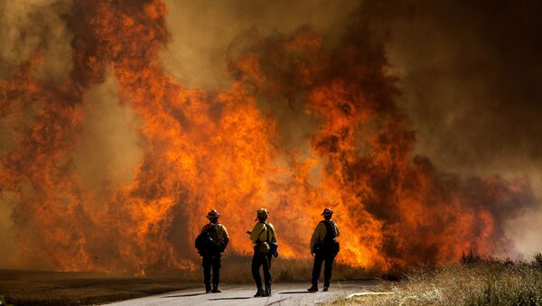 米カリフォルニア州チェリーバレーで燃え上がる炎を見つめる消防士ら - Sputnik 日本