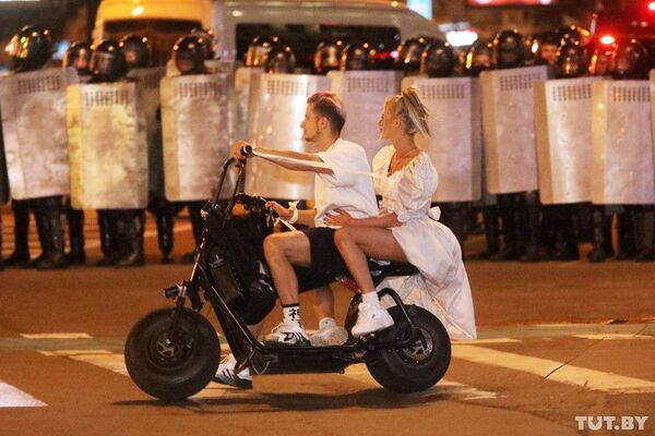 8月9日、ベラルーシの首都ミンスクで、大統領選の投票締め切り後、封鎖された通りをスクーターで走る男女 - Sputnik 日本