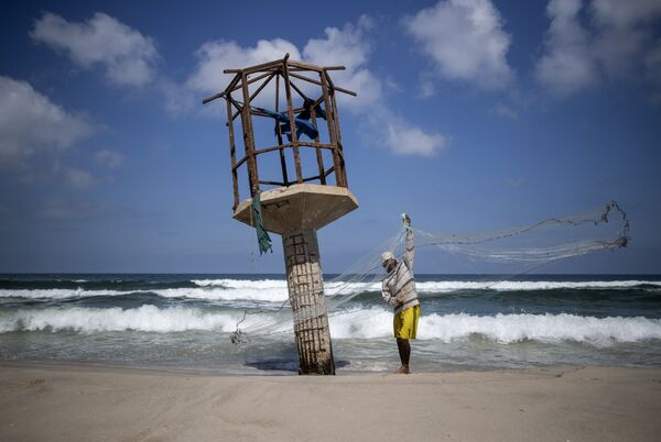 8月18日、パレスチナ自治区ガザ地区のビーチで漁網を片付ける漁師 - Sputnik 日本