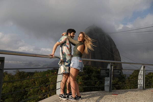 8月15日、ブラジルのリオデジャネイロにある奇岩「ポン・ヂ・アスーカル」を背景に写真を撮る男女 - Sputnik 日本