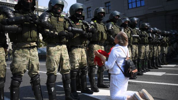 Участница акции протеста и сотрудники правоохранительных органов на проспекте Независимости в Минске - Sputnik 日本