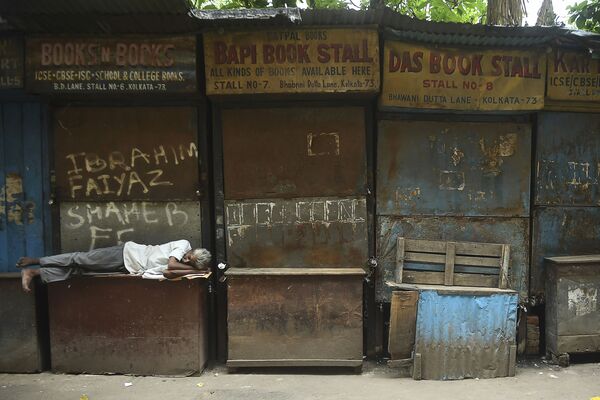 8月30日、インドのコルカタでロックダウン中に閉店した売店の前に寝そべる男性  - Sputnik 日本