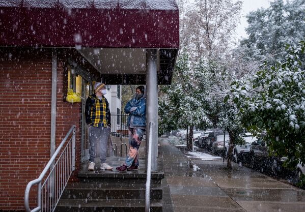 9月8日、コロラド州の州都デンバーで、雪が降る中玄関先に立つ住民 - Sputnik 日本