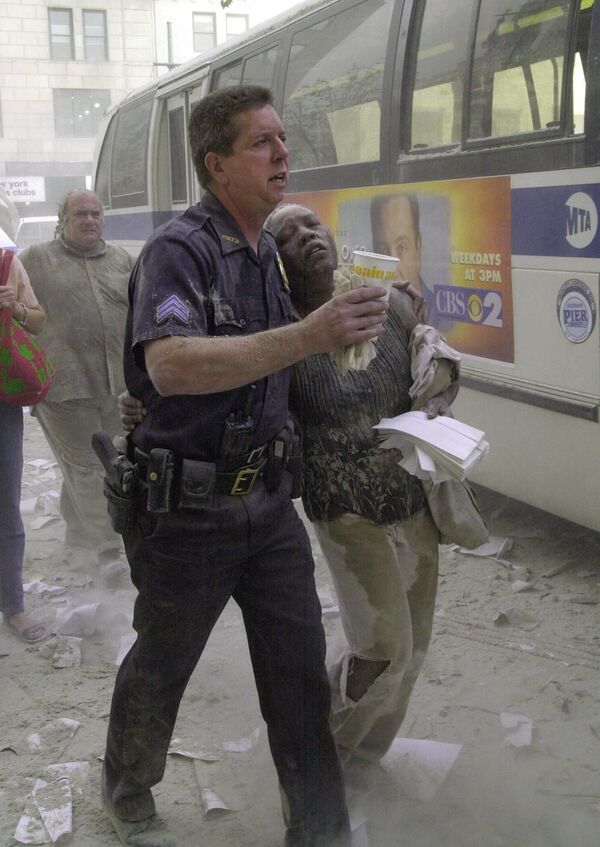 2001年9月11日、世界貿易センタービル付近から避難してきた女性をバスへ乗せる警察官 - Sputnik 日本