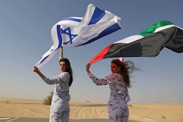 9月8日、アラブ首長国連邦（UAE）のドバイで行われたイスラエルのランジェリーブランドのコレクション終了後、イスラエルとアラブ首長国連邦（UAE）の国旗を掲げる女性モデル - Sputnik 日本
