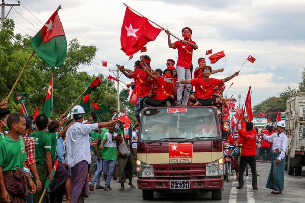 9月19日、ミャンマーのマンダレー近郊で選挙運動中、連邦団結発展党の支持者らのそばを車で通り過ぎる国民民主連盟の支持者 - Sputnik 日本