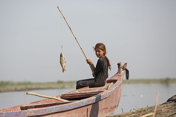 9月23日、イラクのバスラ近郊の湿地で魚を釣る少女 - Sputnik 日本