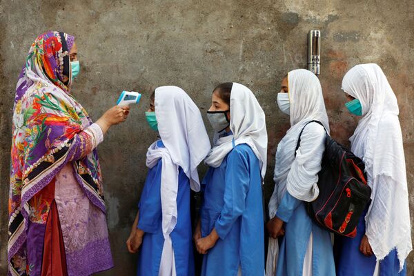 9月23日、パキスタンのペシャーワルの学校で、授業前に生徒の体温測定を行う教師 - Sputnik 日本