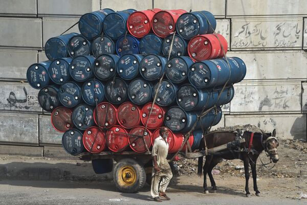 9月27日、パキスタンのラホールでドラム缶を積んだ馬車の横に立つ男性 - Sputnik 日本