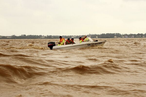 洪水で冠水したベトナム北中部クアンビン省で、増水した川をボートで移動する救助隊員ら（10月12日） - Sputnik 日本