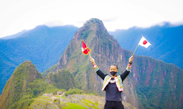マチュピチュ遺跡を背景にペルーの国旗と日本の国旗を掲げる片山さん（10月13日） - Sputnik 日本