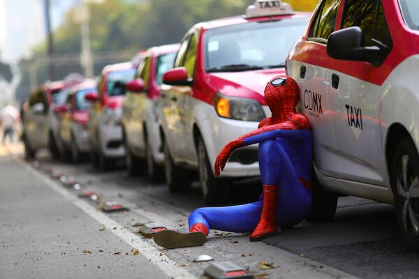 メキシコ首都メキシコシティで、配車アプリに対する規制強化を求める抗議デモの最中、スパイダーマンの格好でタクシーの脇に座る市民 - Sputnik 日本