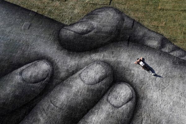 トルコのイスタンブールにある金角湾で、巨大アート「人間の鎖」の上に寝そべるアーティスト - Sputnik 日本