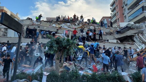 Спасатели и местные жители эвакуируют пострадавших во время обрушения здания в результате землетрясения, Измир, Турция - Sputnik 日本
