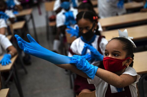 キューバ首都ハバナで11月2日、授業中に手袋をはめる女子児童 - Sputnik 日本