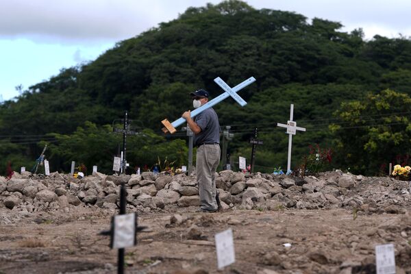 ホンジュラスの首都テグシガルパで11月2日、十字架を背負って墓地を歩く男性 - Sputnik 日本