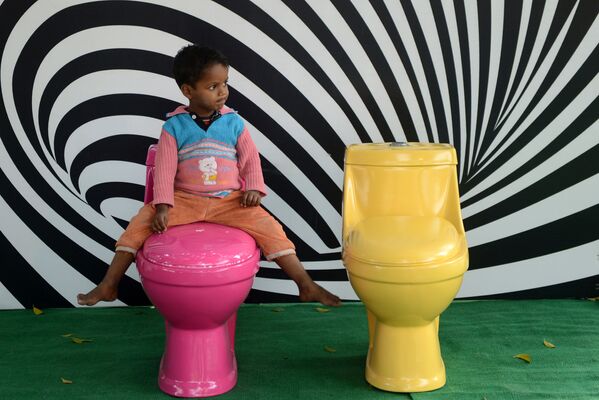 インドのニューデリーで開催された「世界トイレの日」を記念したイベントで、トイレにまたがる少女（2012年11月19日） - Sputnik 日本