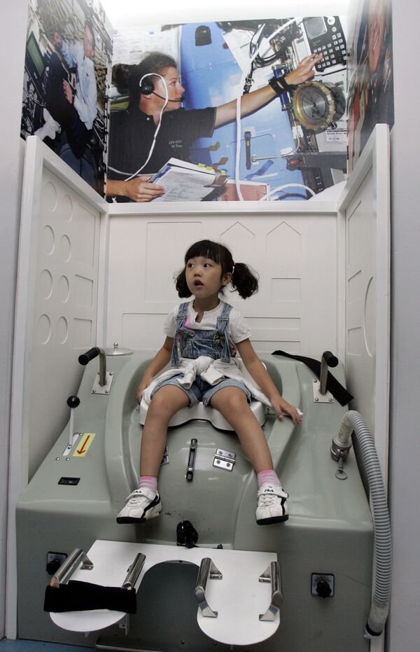 韓国のソウルで開催された宇宙体験フェアで、宇宙船のトイレの中に座る少女（2007年9月5日） - Sputnik 日本