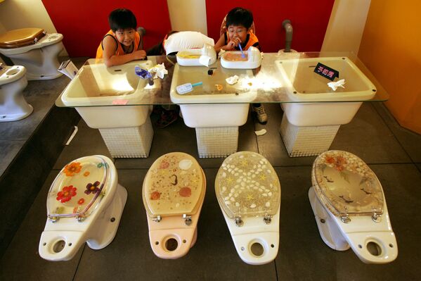 台湾南部の港町、高雄にあるトイレをテーマにしたカフェでアイスを食べる少年（2005年5月29日） - Sputnik 日本