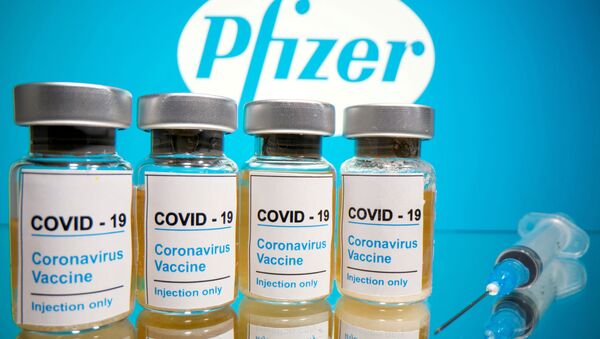 Бутылочки с вакциной от коронавируса на фоне логотпипа Pfizer - Sputnik 日本