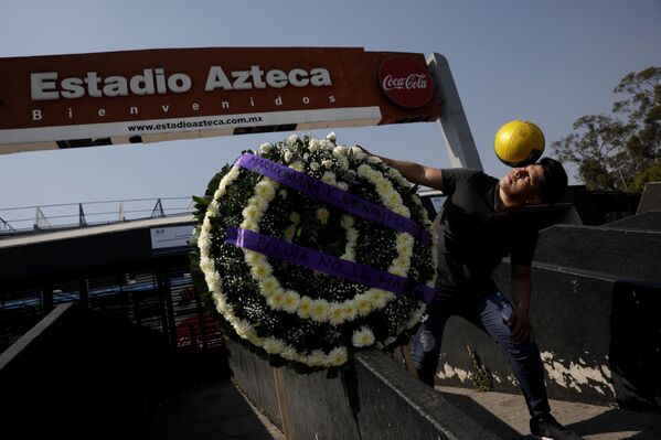 メキシコのメキシコシティにあるスタジアム「エスタディオ・アステカ」でマラドーナ氏を追悼する花輪の横で記念撮影するファン - Sputnik 日本