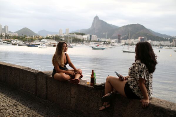 ブラジルのリオデジャネイロで、川岸に座ってビールを飲む女性 - Sputnik 日本