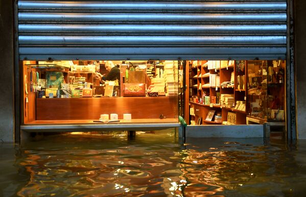 サン・マルコ広場に連なるアーケード街で、店内への水の浸入を防ぐ店主 - Sputnik 日本