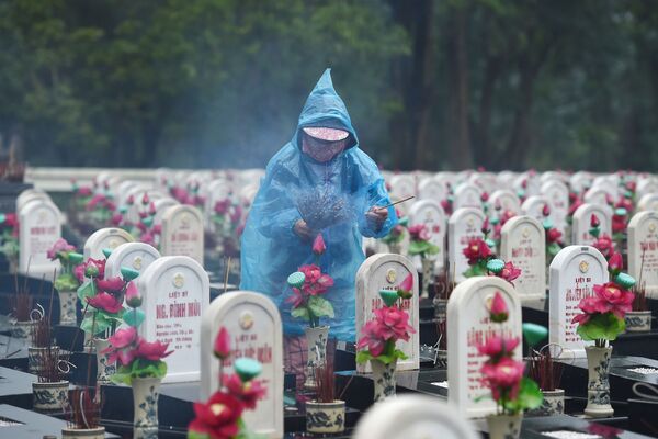 ベトナムのクアンチ省にあるチュオンソン戦没者墓地で線香をあげる訪問者 - Sputnik 日本