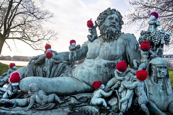 デンマークの首都コペンハーゲンの赤い帽子とマスクを着けたブロンズ像 - Sputnik 日本