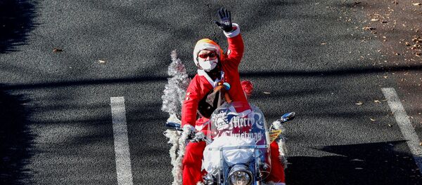 Мужчина в костюме Санта-Клауса на мотоцикле Harley Davidson во время рождественского парада в Токио Мужчина в костюме Санта-Клауса на мотоцикле Harley Davidson во время рождественского парада в Токио - Sputnik 日本