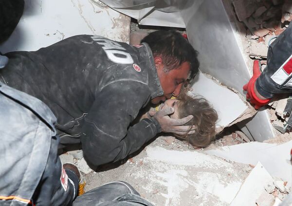 エーゲ海地震に襲われたトルコ西部イズミル県で、がれきの中から女児を救助する救助隊員（11月3日撮影） - Sputnik 日本
