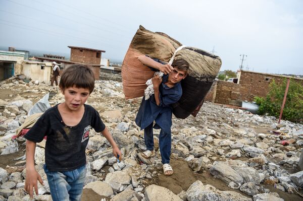 鉄砲水が発生したアフガニスタン東部パルワン州で、瓦礫から持ち物を回収する村人ら（8月26日撮影） - Sputnik 日本