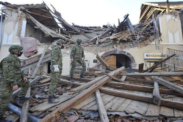 中部・ペトリニャで全壊した建物の周りを歩く兵士ら - Sputnik 日本