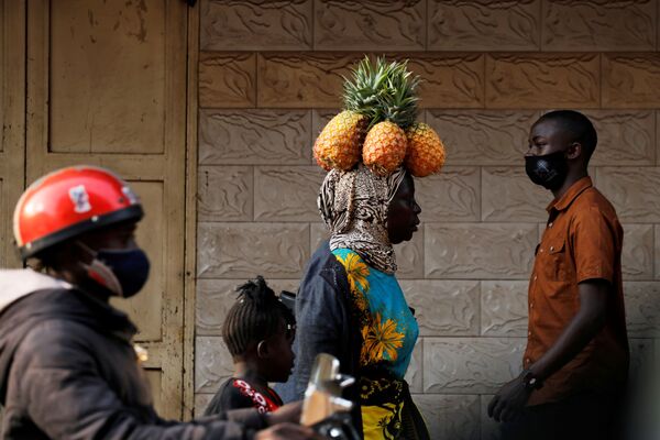 ウガンダ首都・カンパラで頭にパイナップルを乗せて歩く女性 - Sputnik 日本