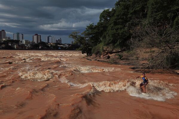 雨季が到来したブラジル・ミナスジェライス州のゴベルナドル・バラダレスで、水位が上昇した川でサーフィンをする男性 - Sputnik 日本