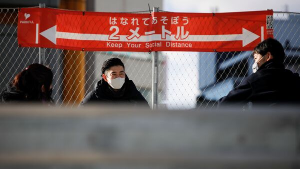Люди в масках на фоне плаката о необходимости соблюдения социальной дистанции в Токио - Sputnik 日本