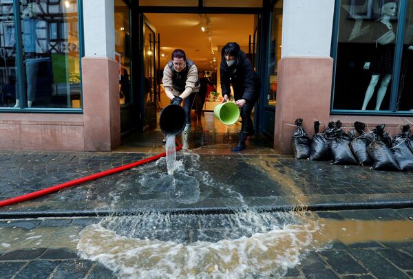 ドイツ・フランクフルト近郊のビューディンゲンで、大雨によって浸水した店舗を清掃するドレスショップの従業員 - Sputnik 日本