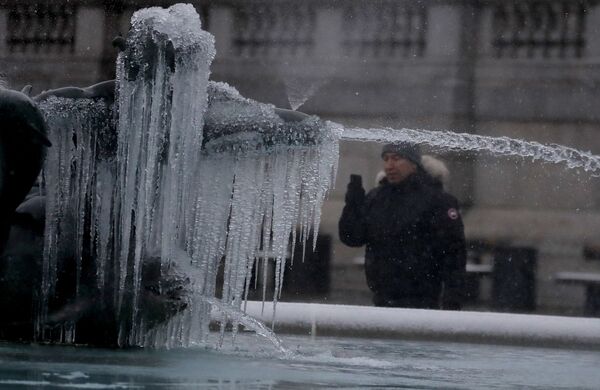 英ロンドンのトラファルガー広場で、氷に覆われた噴水の写真を撮る男性 - Sputnik 日本