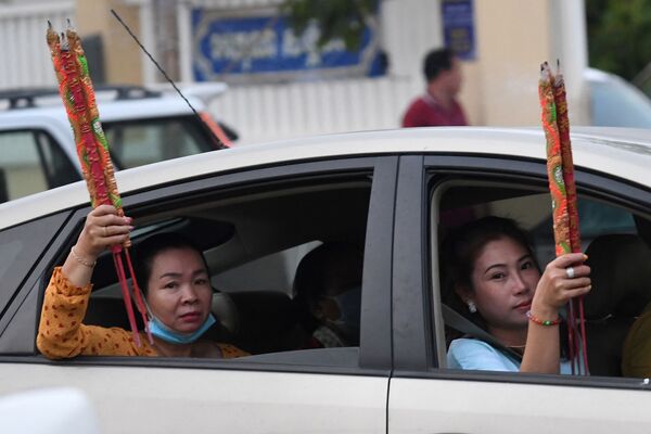 カンボジア・カンダル州タクマウ村で、中華正月（旧正月）を祝って寺院を訪れた後、車内で線香を掲げる女性たち - Sputnik 日本
