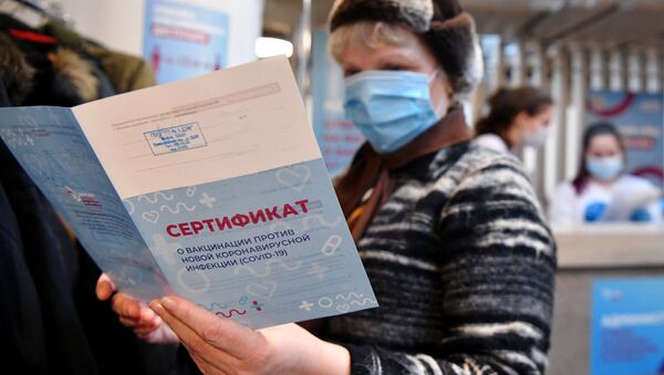 Женщина держит в руках сертификат о вакцинации от СOVID-19 - Sputnik 日本