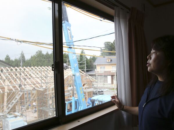 福島県双葉郡楢葉町で、建設中の隣人の住宅を自宅窓から眺める女性（2015年9月4日撮影） - Sputnik 日本