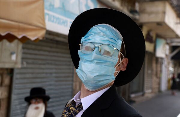 イスラエル・エルサレム郊外のメア・シャリムでマスクを複数枚顔にかける男性 - Sputnik 日本